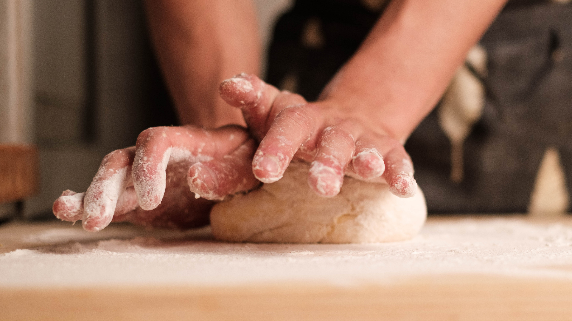 Hands Kneading Bread Dough on Wooden Board